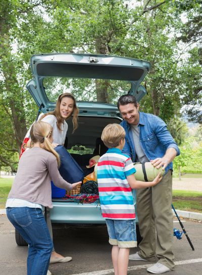 Family unloading car trunk while on picnic