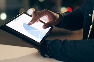 Black man, tablet and working at night in office with...