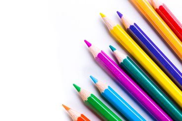 Colorful pencils arranged in a neat line on a white...