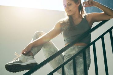 Fitness, woman and stretching legs on rail in...