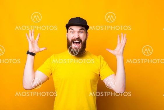 Portrait of young bearded hipster man making surprised...