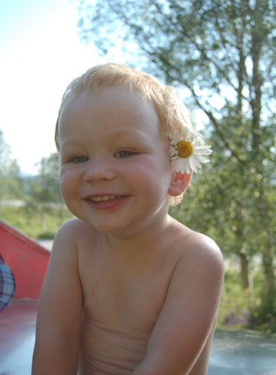 Liten pojke med blomma