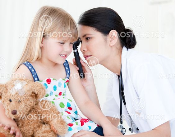 Asian doctor examining little girl with medical equipment