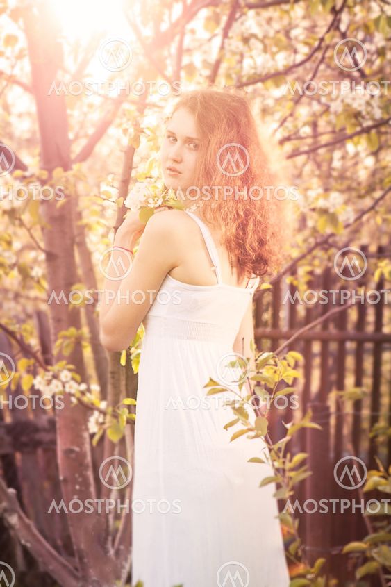 Beautiful young woman with gorgeous curly fair outdoors