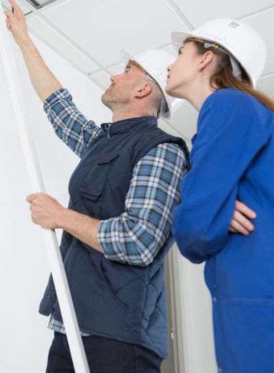 electricians installing ceiling lights in domestic home