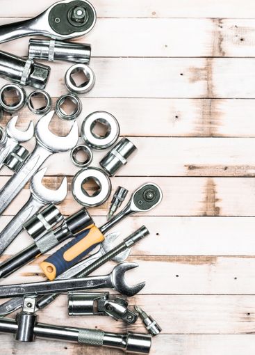 Collection of metallic tools arranged on a wooden...