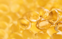 Banner closeup of oil gel capsules on yellow background.