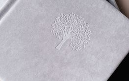 A photo book in a grey cloth cover lies on the box. the...