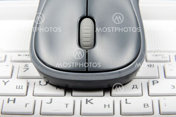 A wireless mouse placed on laptop keyboard
