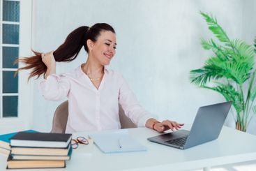 Brunette businesswoman sitting at desk in office with...