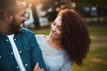 Love, couple and happy at park together for sunset date,...