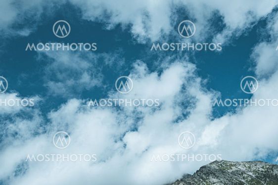 Rocky ridge on horizon under blue cloudy sky. Mountain...
