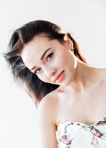 Beautiful brunette woman in summer dress with flowers on...