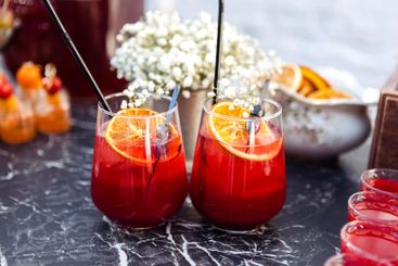 Close-up of two glasses with a berry cocktail on a black...