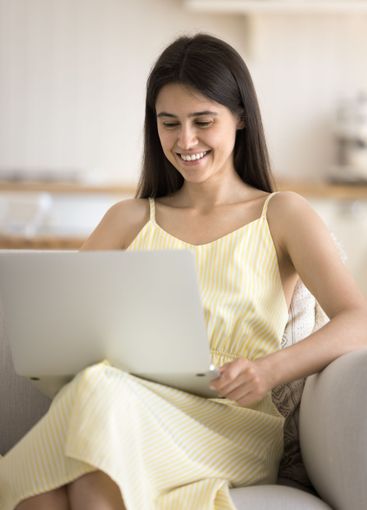 Smiling young woman enjoy working from home office using...