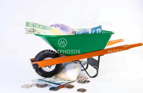 Green wheel barrel full of dollars bills