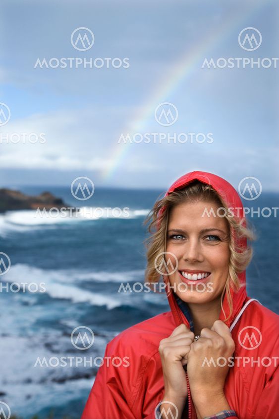 Woman smiling by rainbow.
