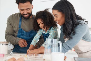 Baking, dough and parents with child in kitchen with...