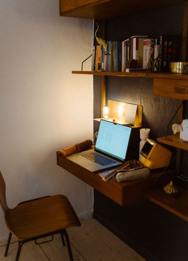 High angle view of laptop on desk in shelf at home