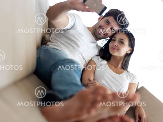 young couple making selfie together at home