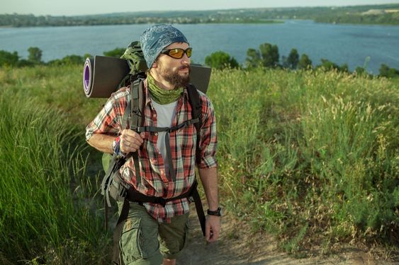 Young caucasian man with backpack walking on the top of...