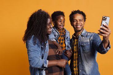 Sweet happy family with a small toddler take photos on...