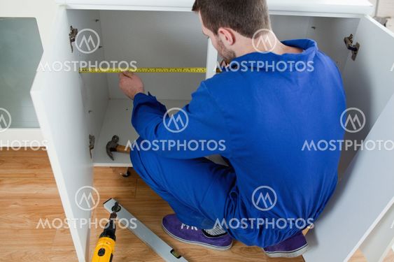 Young repair man measuring something