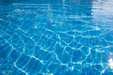 Bright blue swimming pool water reflecting sunlight...