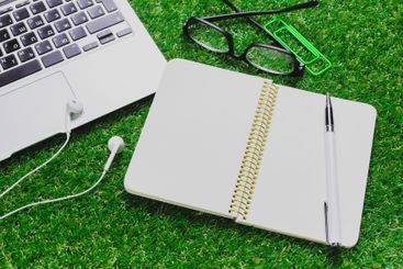 Colorful workspace setup with open notebook, laptop, and...