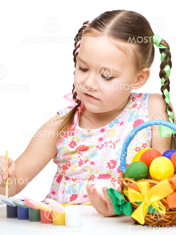 Little girl is painting eggs preparing for Easter