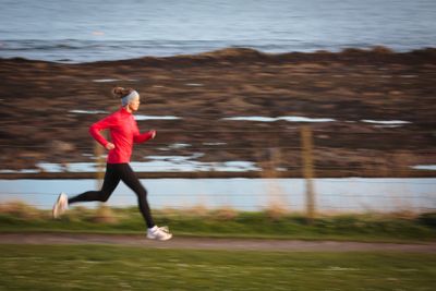 Young woman on her evening jog along the seacoast
