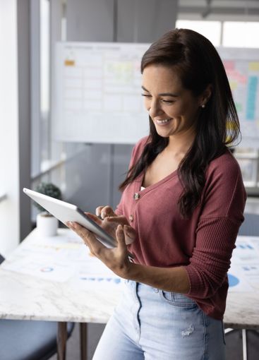 Happy young female business professional woman using...