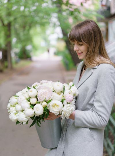 Beautiful bouquet of white peonies in woomans hands ....