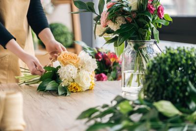 Partial view of florist making bouquet in flower shop