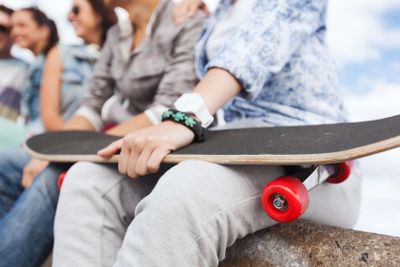 close up of female hand holding skateboard
