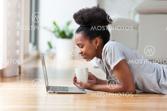 African American woman using a laptop in her living room...
