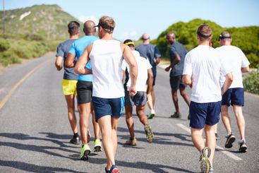 Group, competition and men with running in road for...