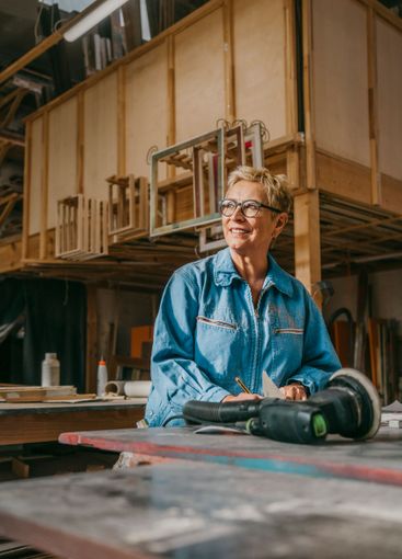 Smiling senior female carpenter contemplating at workshop