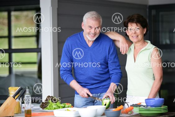 Middle-aged couple cooking outdoors together