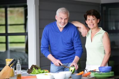 Middle-aged couple cooking outdoors together