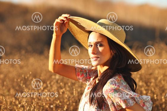 Young Beautiful Woman on a Field in Summer Time