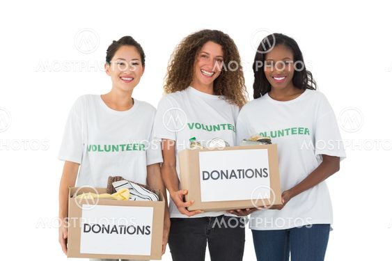 Team of volunteers smiling at camera holding donations boxes