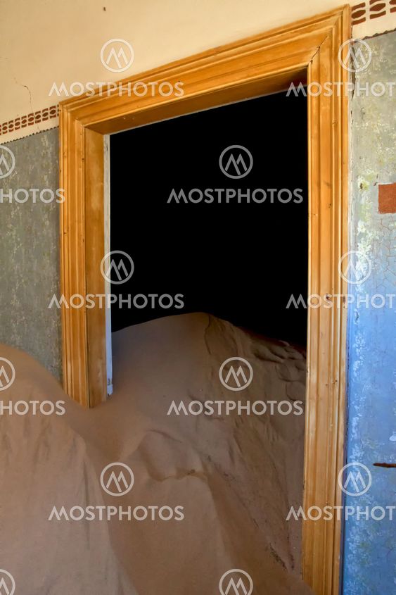 a dune coming from a door in a house at kolmanskop ghost town namibia africa