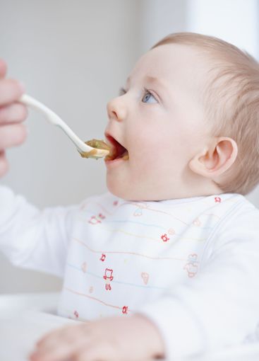 Baby food, parent hands and feeding in home, hungry and...