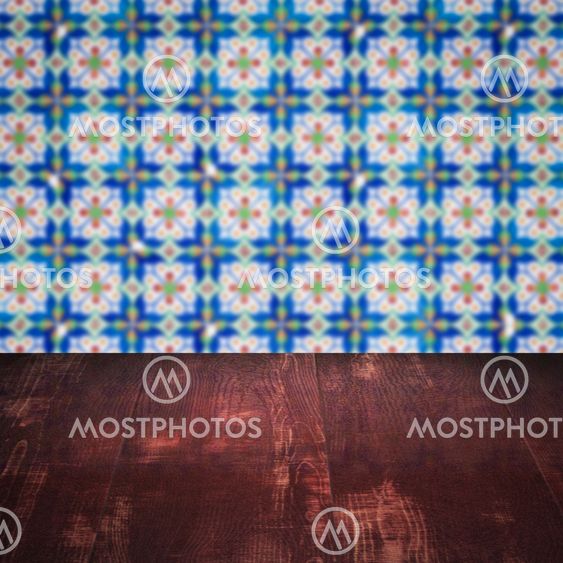 Wood table top and blur vintage ceramic tile pattern wall