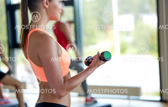 group of women with dumbbells and steppers