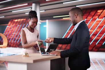 Woman At Hotel Talking To Receptionist Man