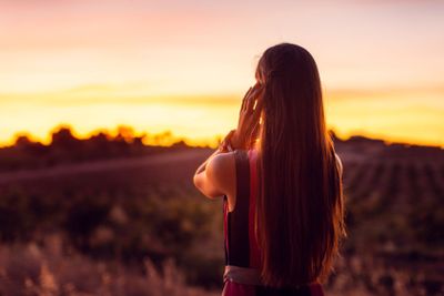 Woman watching the afterglow in an olive grove