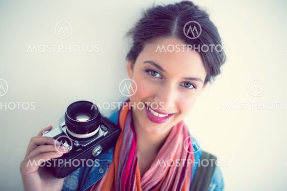 Attractive brunette holding camera smiling