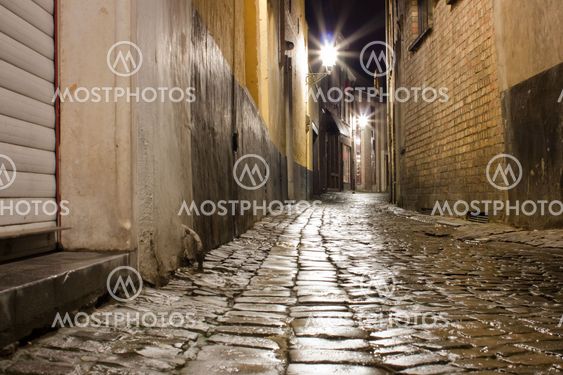 Old wet cobblestone street after rain at night